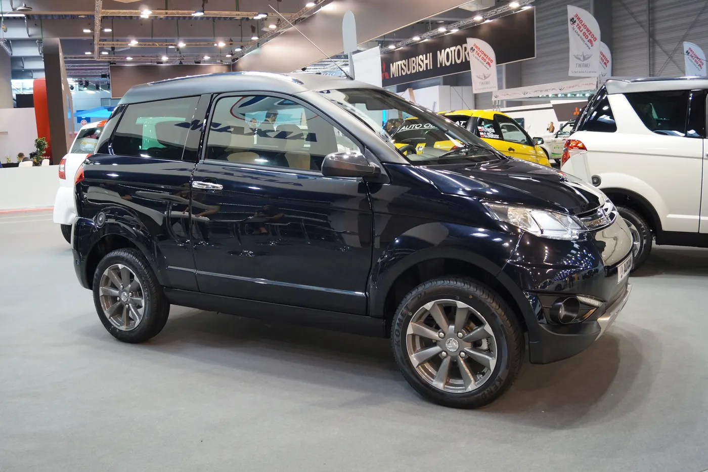 Granatowy Aixam Crossover GTR na stoisku targów motoryzacyjnych