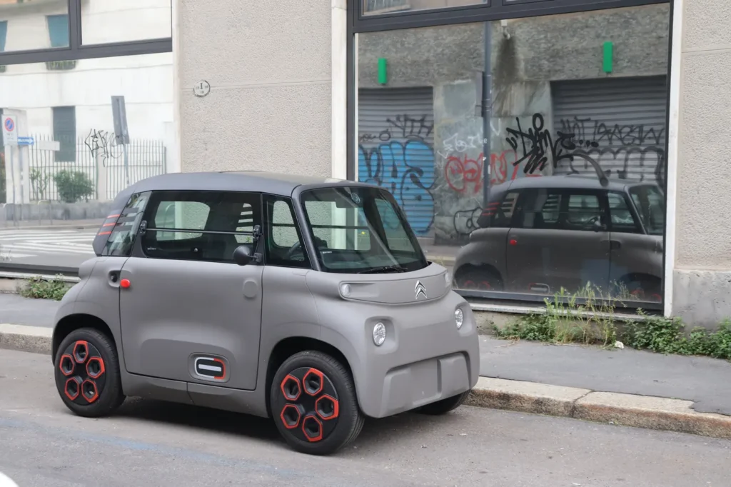 Samochód bez prawa jazdy – kategoria AM, przepisy i ceny Szary Citroën Ami zaparkowany przy krawężniku na ulicy w Mediolanie